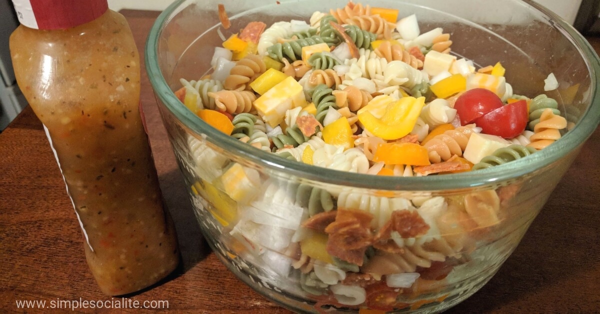 Bowl of Rotini Pasta Salad with Italian Dressing next to it