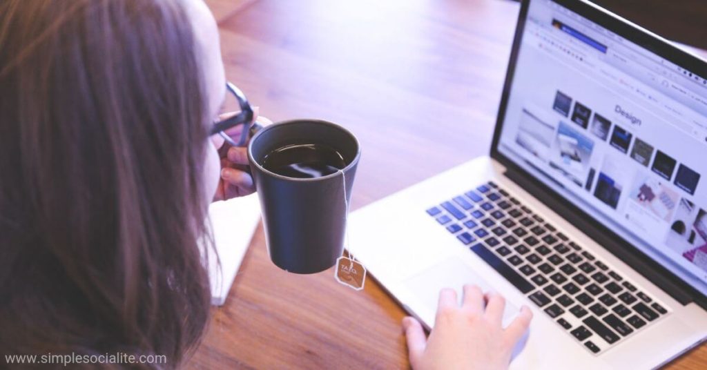 Woman working on her laptop while drinking a cup of tea