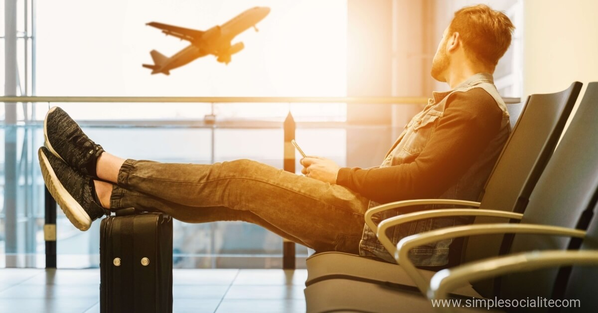 Man waiting at the airport watching a plane take off