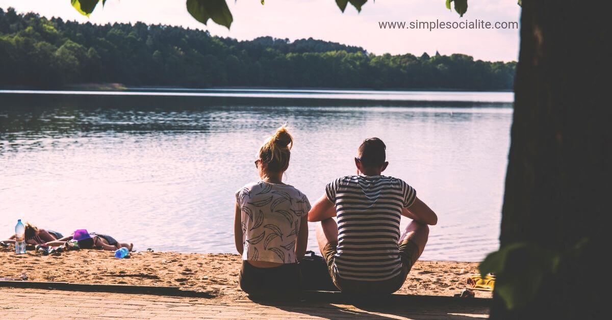 Couple looking out over a lake while enjoying a budget-friendly date at the beach